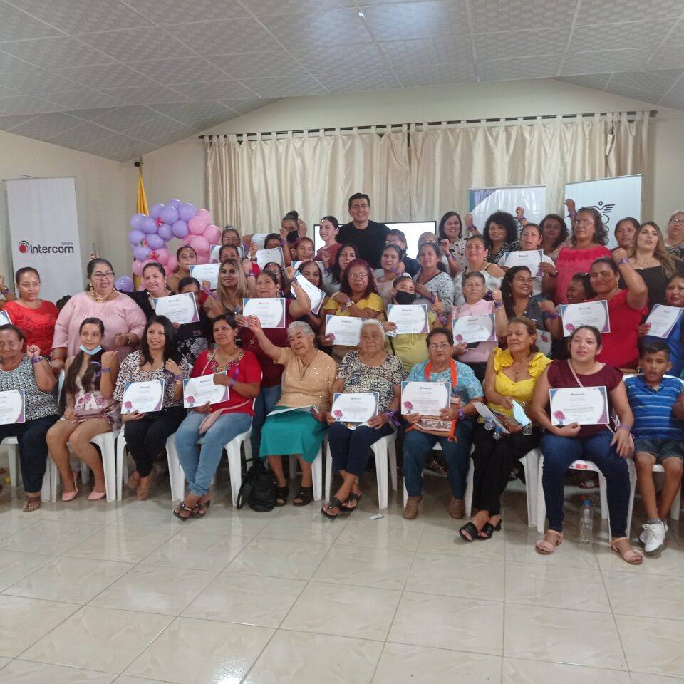 Grupo de mujeres mostrando sus certificados al terminar un taller