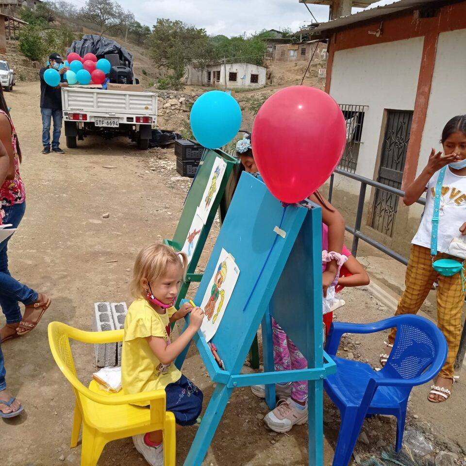 Niña pintando en un caballete durante una actividad de la fundación en su comunidad